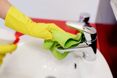 Cleaner tidying a modern Bermondsey apartment kitchen